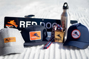 A selection of Palisades Tahoe Cup merchandise on groomed snow.